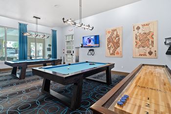 A room with a pool table and a tv.